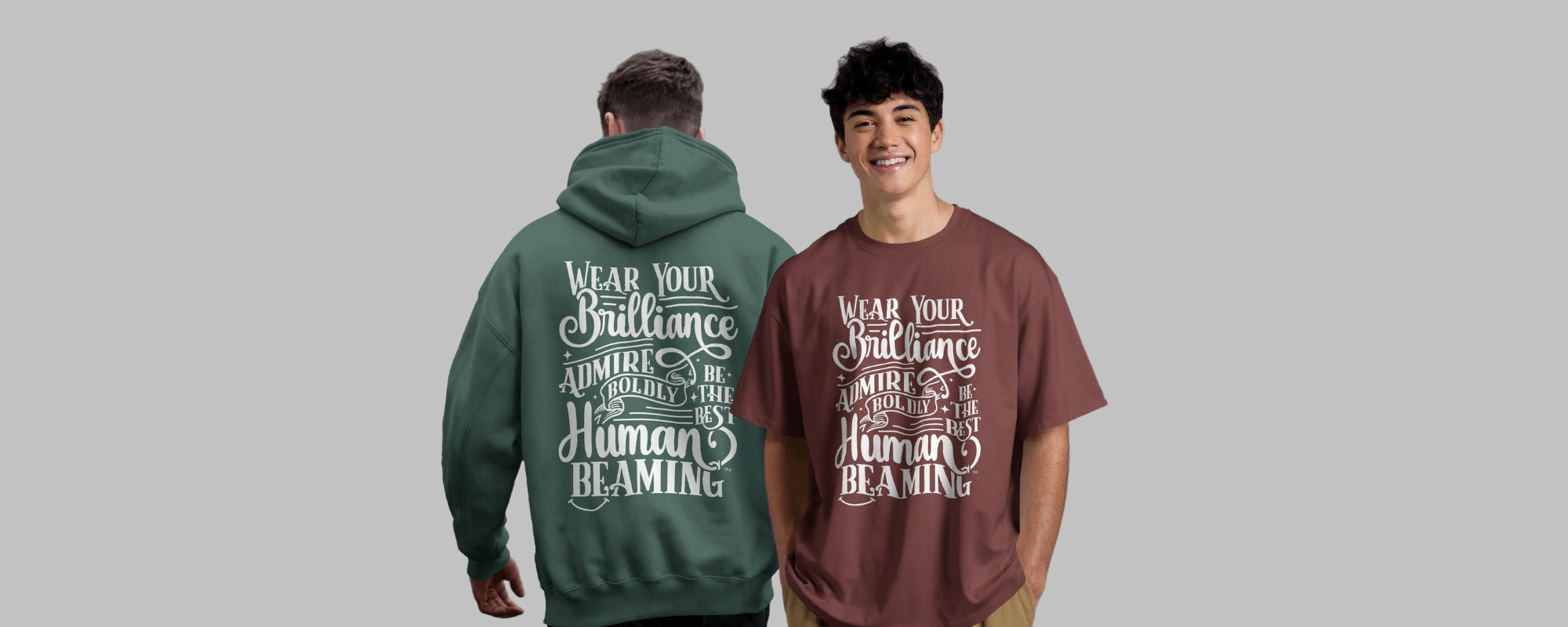 Two people wearing Best Human Beaming “Wear Your Brilliance” collection—one in a green hoodie (back view) and one in a maroon t-shirt (front view). Promotes positivity and self-expression.