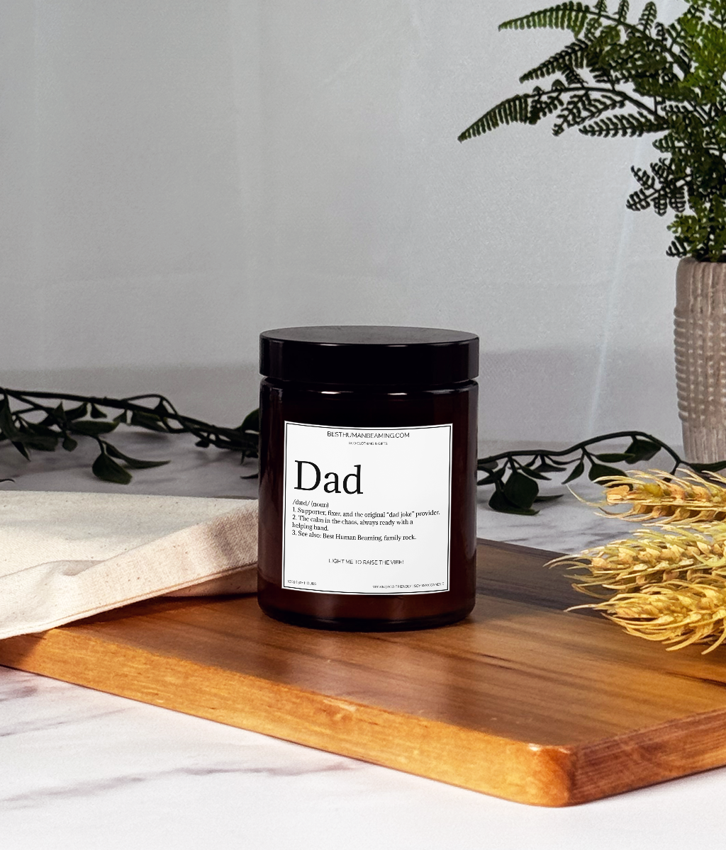 A hand-poured eco-friendly candle in a minimalist glass jar, featuring the Best Human Beaming label. The candle is styled on a clean surface with soft, natural lighting, radiating a warm, inviting glow—perfect for creating a calming and uplifting atmosphere.