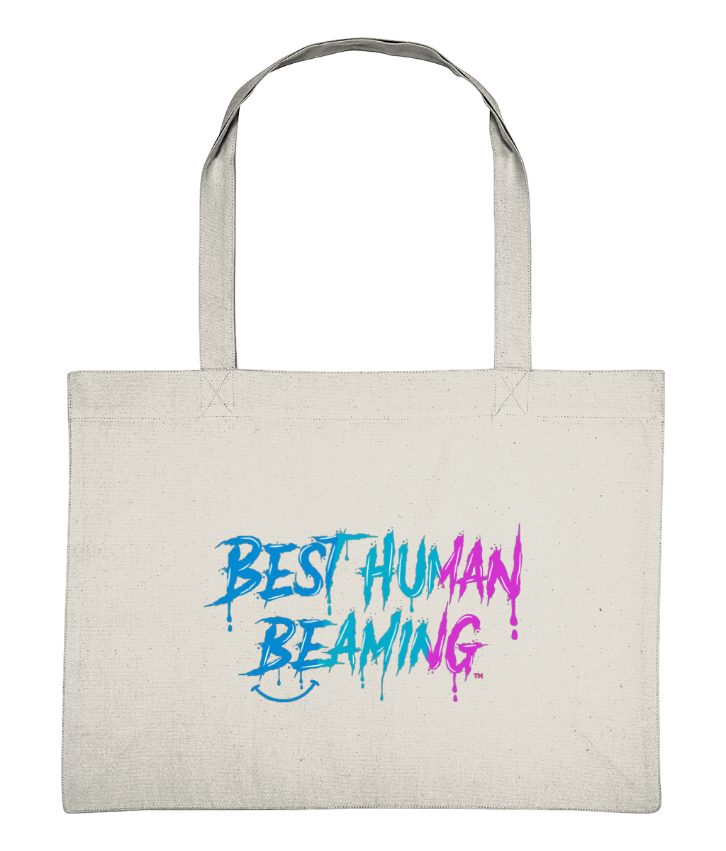 Large natural canvas tote bag with long handles, featuring the “Best Human Beaming” logo in bold blue-to-pink graffiti lettering. Eco-friendly, vegan tote bag made from recycled cotton and polyester—perfect for shopping, errands, or gifting with positive energy and sustainable style.