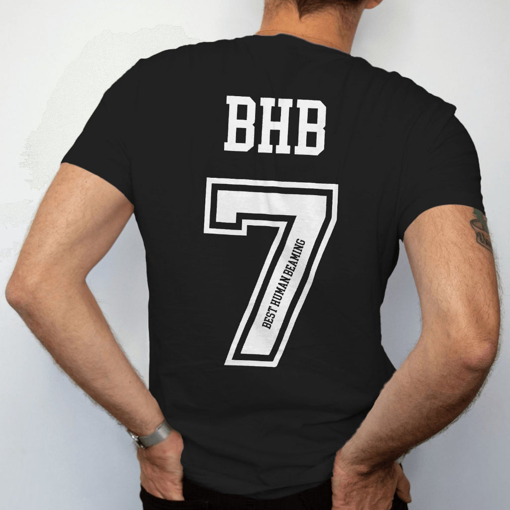 Back view of a man in a black Best Human Beaming t-shirt with bold white “BHB” and a large number 7, “Best Human Beaming” printed along the digit. Sporty, confident style.