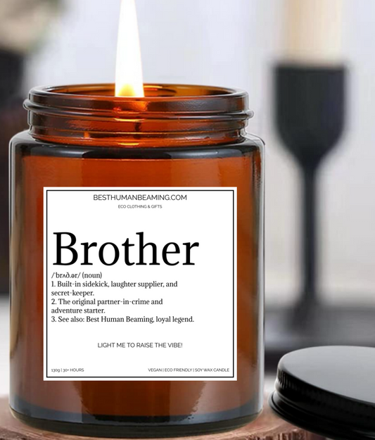 Amber glass soy wax candle with a white label featuring the word “Brother” and a playful definition about being a loyal sidekick and laughter supplier. Sustainable, vegan-friendly candle gift for brothers, by Best Human Beaming—ideal for birthdays, celebrations, or thoughtful gifting.